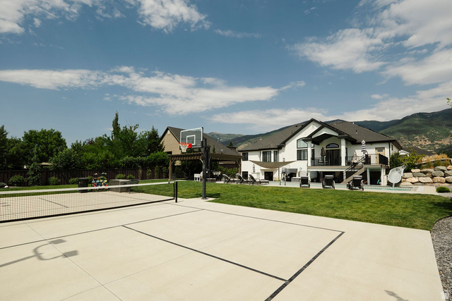 924 Country Lane Farmington, UT 84025 - Photo 79 of 91 Expansive backyard featuring a multi-sport court with basketball hoop and net, manicured lawn, and mountain backdrop