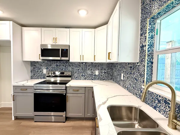 a kitchen with a sink a stove and microwave