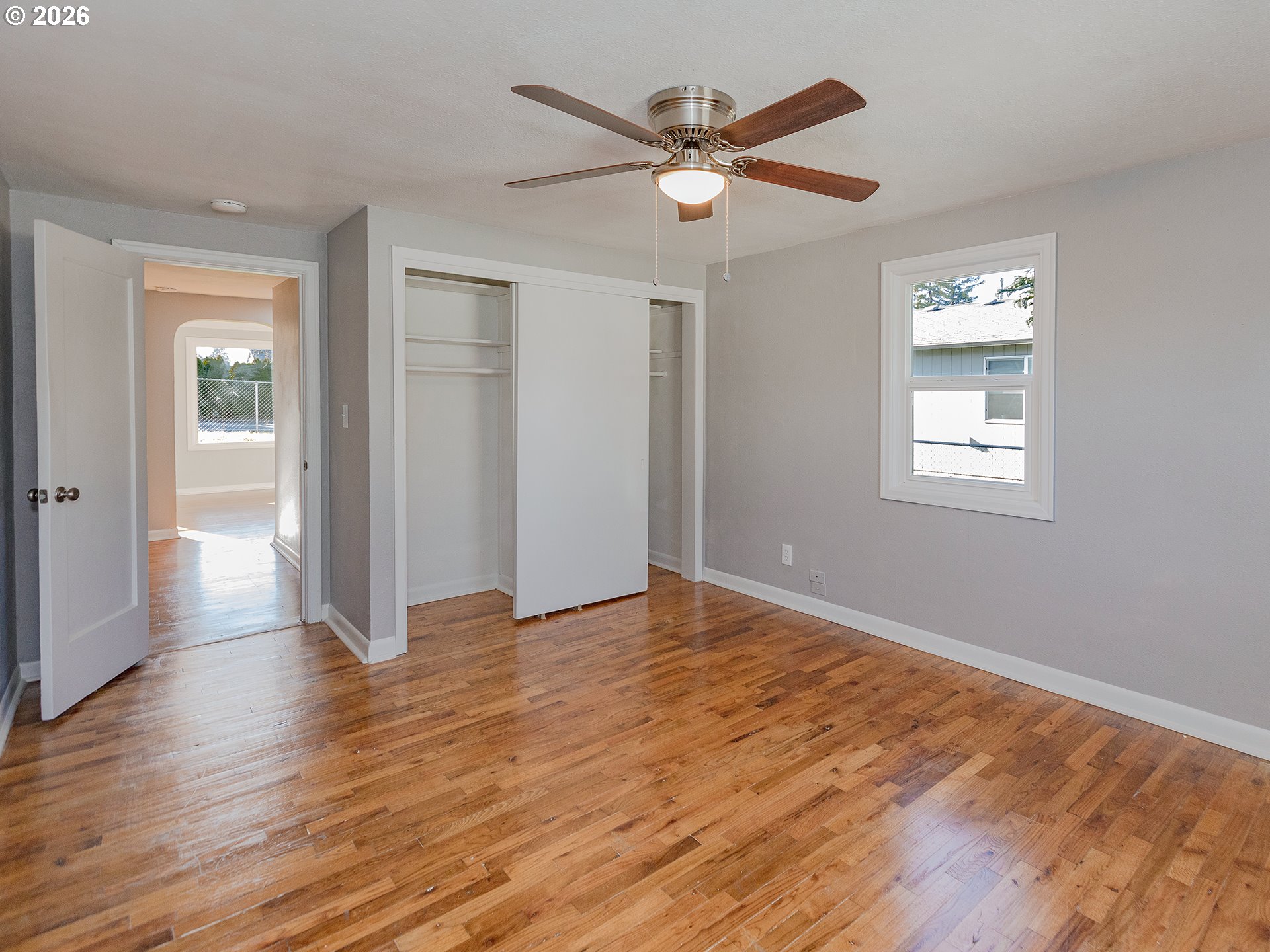 904 East 33rd Street Vancouver, WA 98663 - Photo 20 of 26 an empty room with wooden floor chandelier fan and windows
