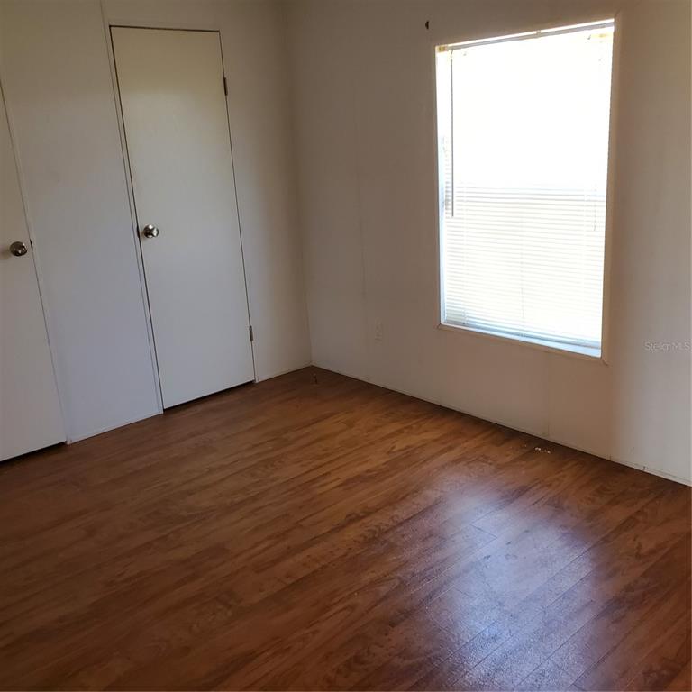2926 Sharon Road Groveland, FL 34736 - Photo 7 of 16 an empty room with wooden floor and windows