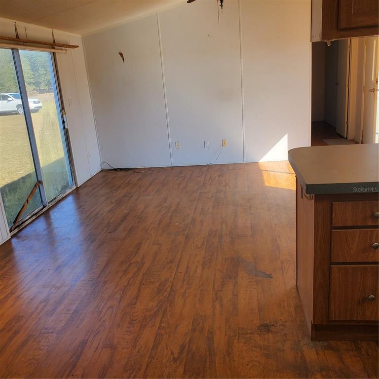 2926 Sharon Road Groveland, FL 34736 - Photo 9 of 16 an empty room with wooden floor and windows