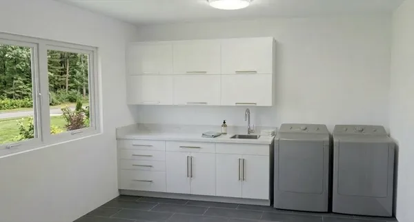 a utility room with cabinets washer and dryer