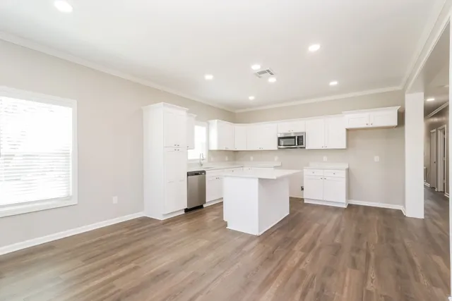 a view of kitchen with wooden floor and electronic appliances