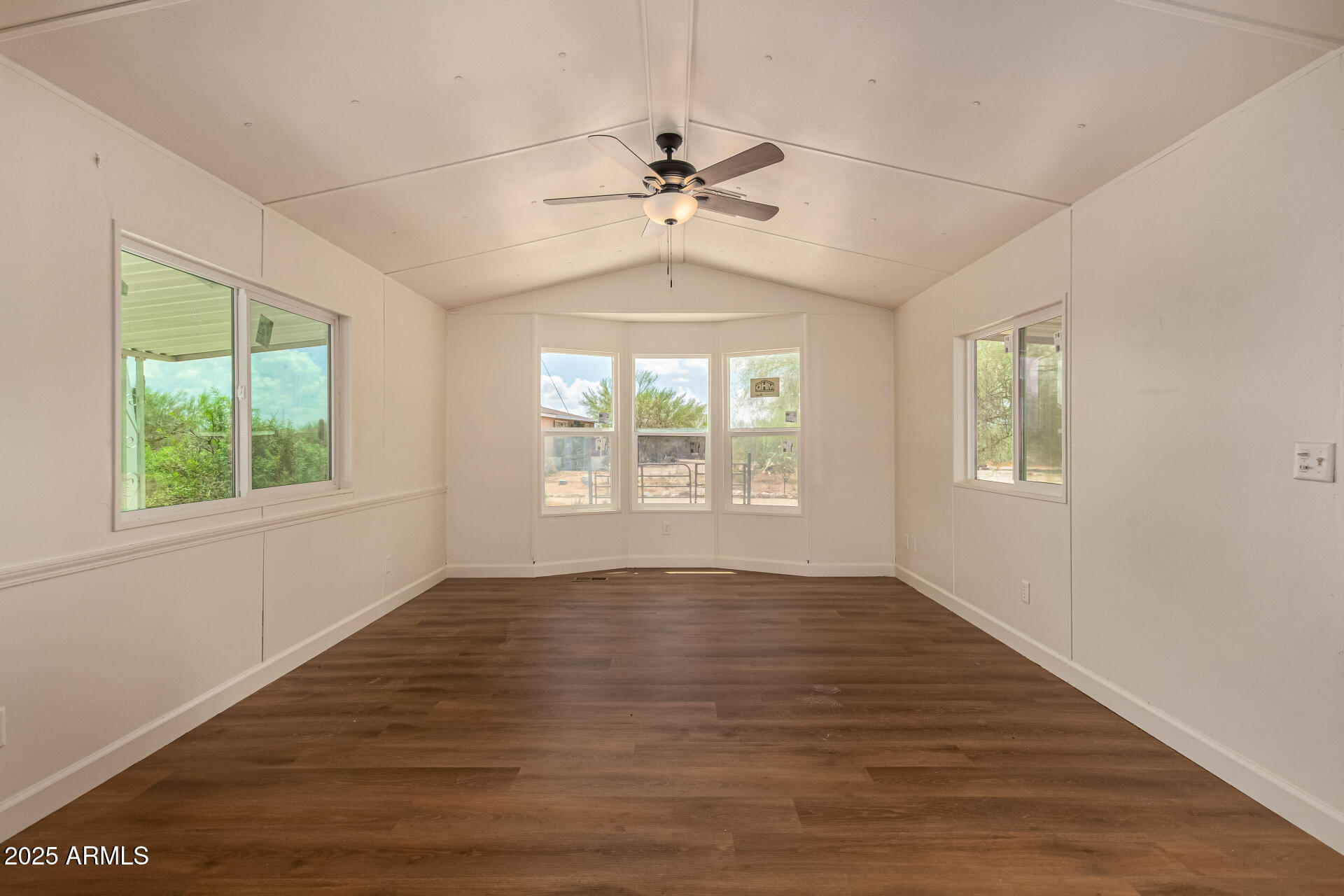 3663 North Thistle Drive Florence, AZ 85132 - Photo 18 of 29 an empty room with wooden floor chandelier fan and windows