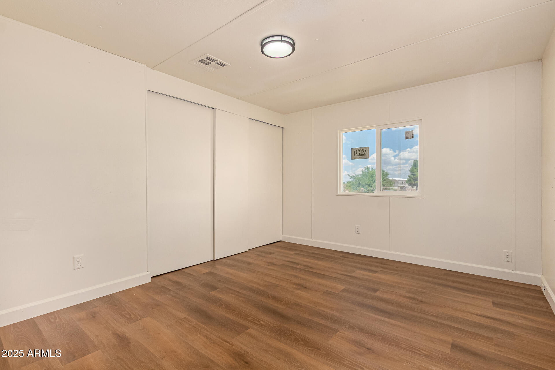3663 North Thistle Drive Florence, AZ 85132 - Photo 21 of 29 an empty room with wooden floor and windows