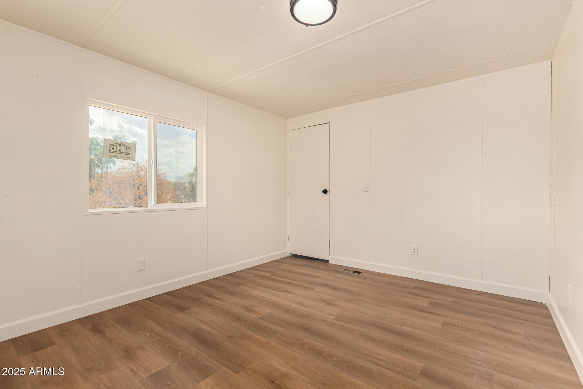 3663 North Thistle Drive Florence, AZ 85132 - Photo 24 of 29 an empty room with wooden floor and windows