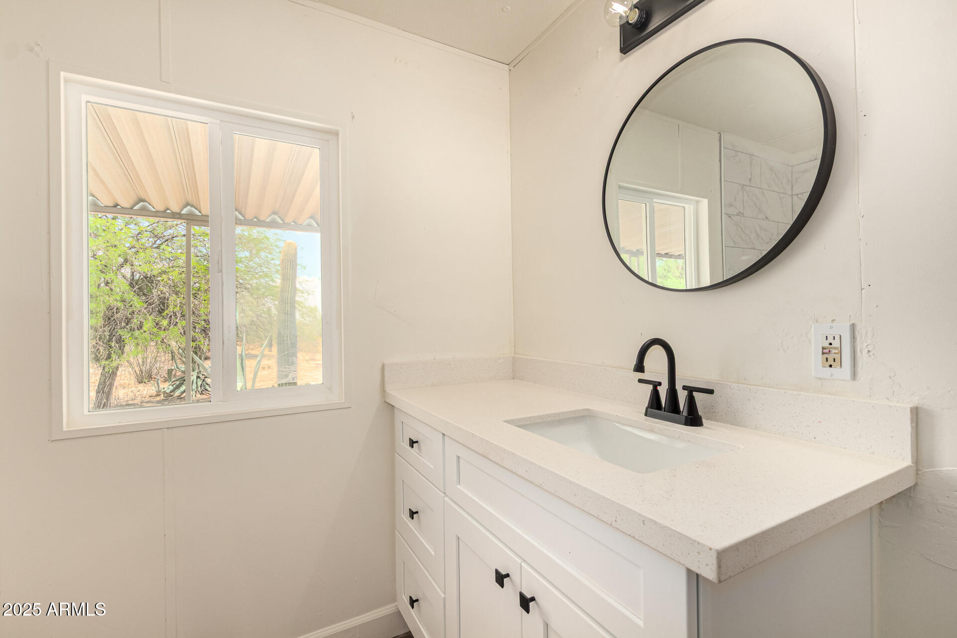 3663 North Thistle Drive Florence, AZ 85132 - Photo 5 of 29 a bathroom with a sink a mirror and a window