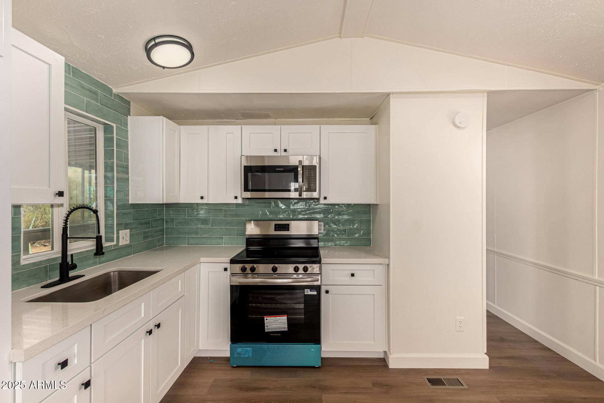3663 North Thistle Drive Florence, AZ 85132 - Photo 7 of 29 a kitchen with stainless steel appliances a stove microwave and sink