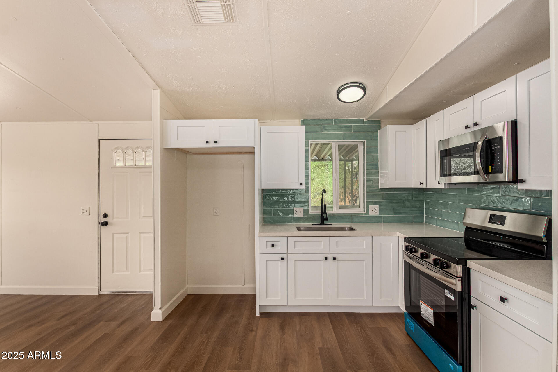 3663 North Thistle Drive Florence, AZ 85132 - Photo 8 of 29 a kitchen with a sink a stove top oven and wooden floor