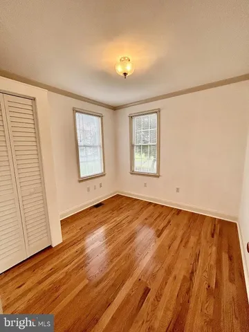 a large white kitchen with granite countertop a dishwasher a stove a dining table and chairs with wooden floor