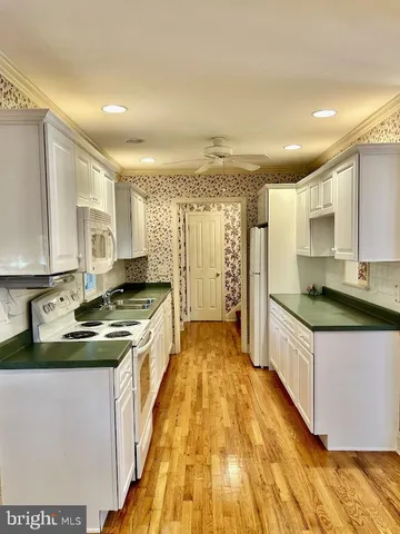 a kitchen with granite countertop wooden floor and a refrigerator