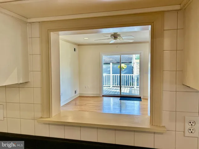 a view of a kitchen with a sink and an empty room