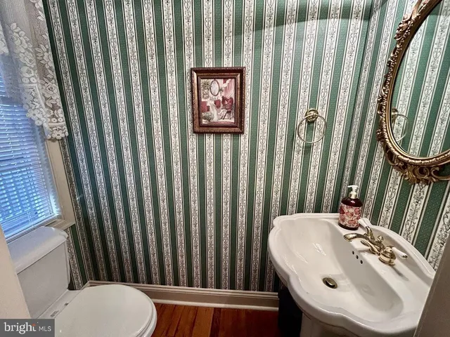 a view of an empty room with closet and wooden floor