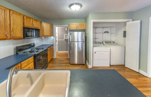 a kitchen with stainless steel appliances granite countertop a refrigerator a stove top oven a sink and dishwasher