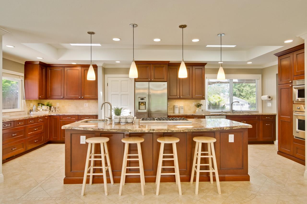 22266 Hartman Drive Cupertino, CA 95014 - Photo 16 of 73 a kitchen with stainless steel appliances granite countertop a stove a sink and a refrigerator