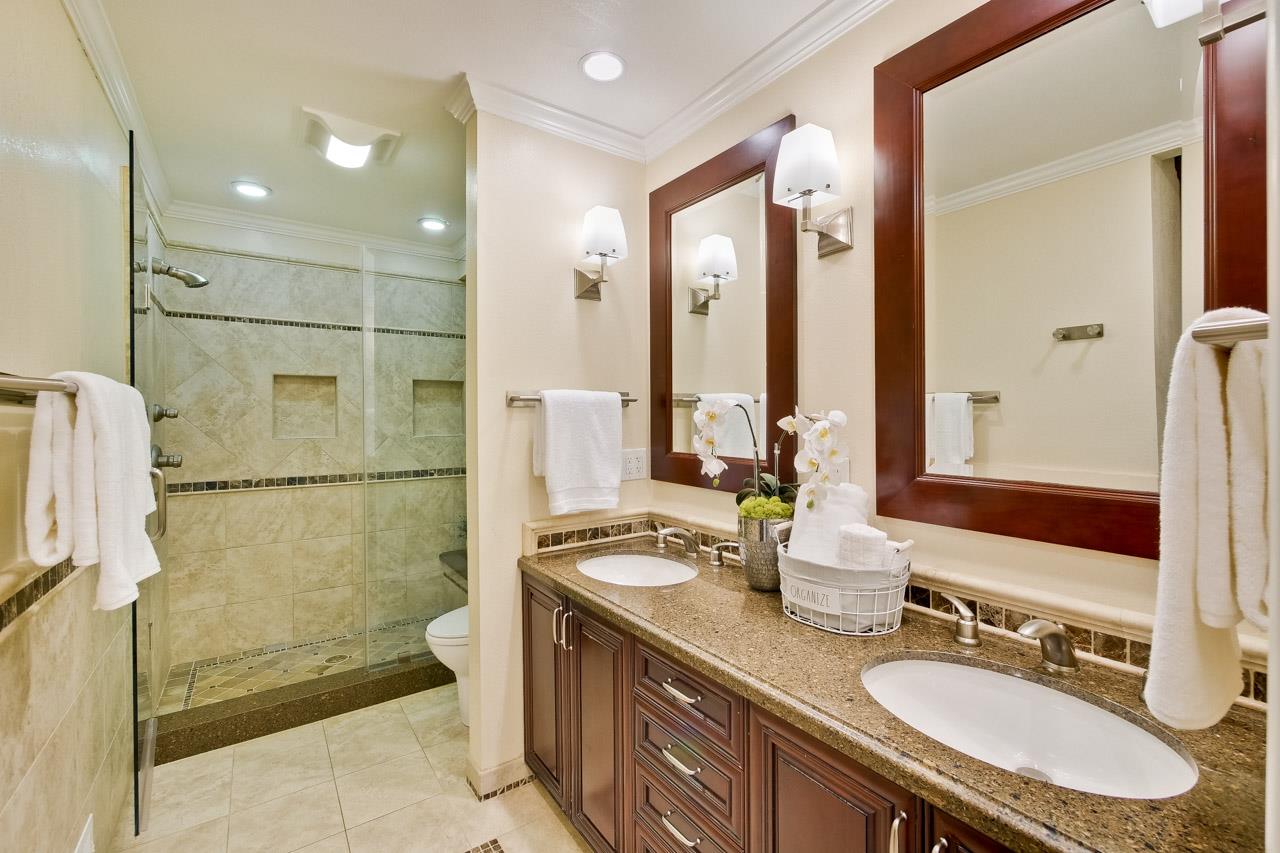 22266 Hartman Drive Cupertino, CA 95014 - Photo 38 of 73 a bathroom with a granite countertop sink a toilet a mirror and shower
