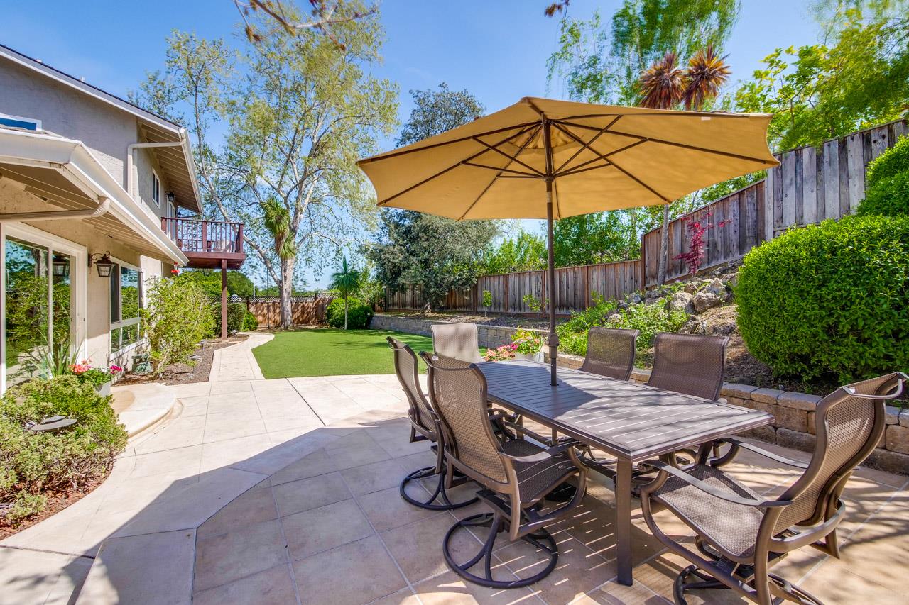 22266 Hartman Drive Cupertino, CA 95014 - Photo 65 of 73 a patio with a table and chairs under an umbrella