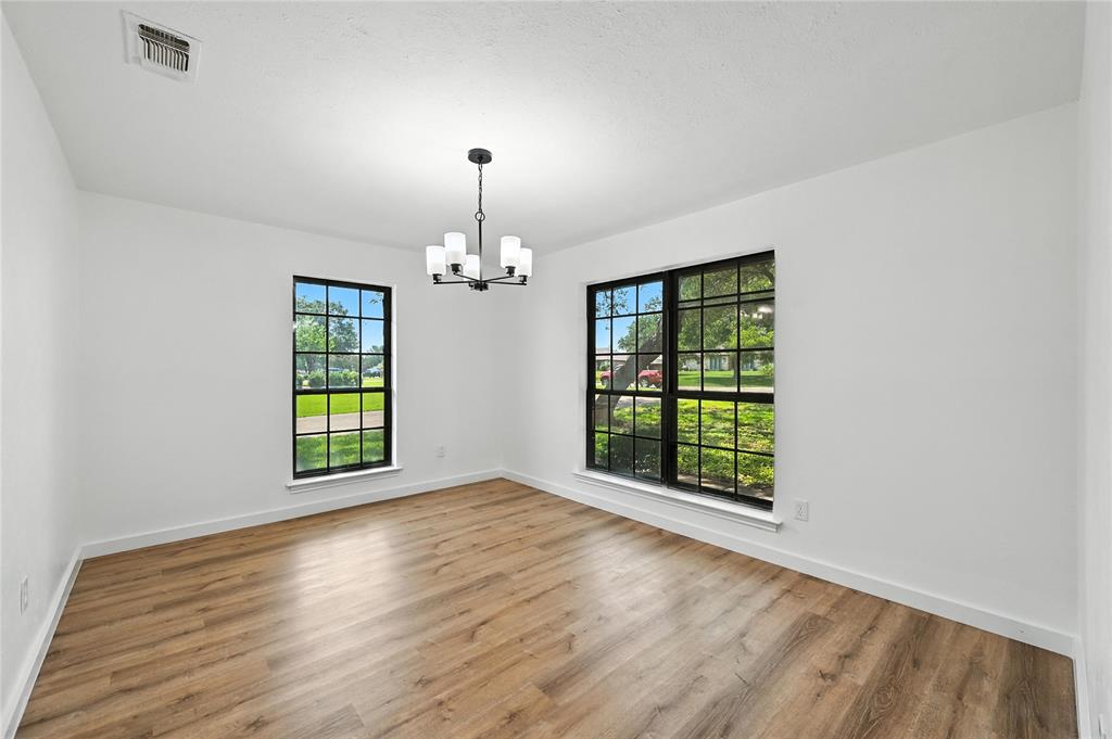 3309 Larkin Lane Rowlett, TX 75089 - Photo 5 of 18 an empty room with wooden floor chandelier and windows