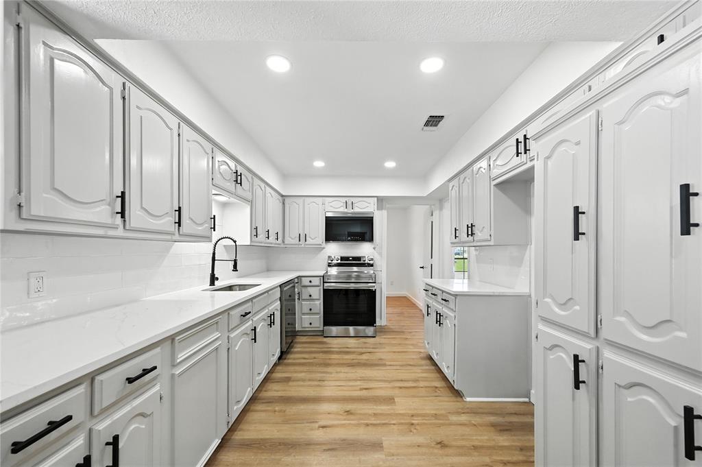 3309 Larkin Lane Rowlett, TX 75089 - Photo 6 of 18 a large kitchen with stainless steel appliances granite countertop a lot of counter space and wooden floor