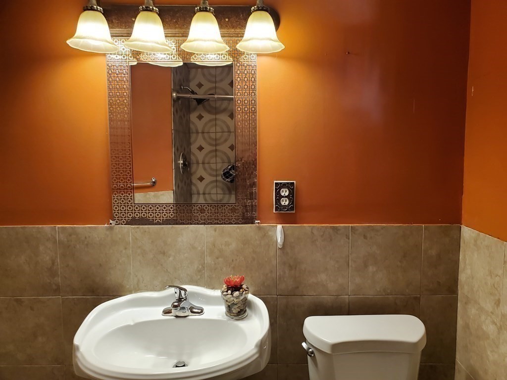 48 Merrill Road Springfield, MA 01119 - Photo 15 of 38 a bathroom with a sink a toilet and a mirror