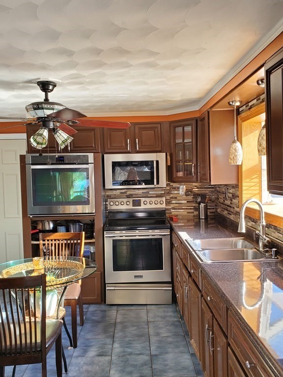 48 Merrill Road Springfield, MA 01119 - Photo 6 of 38 a kitchen with stainless steel appliances granite countertop a stove a sink and a microwave
