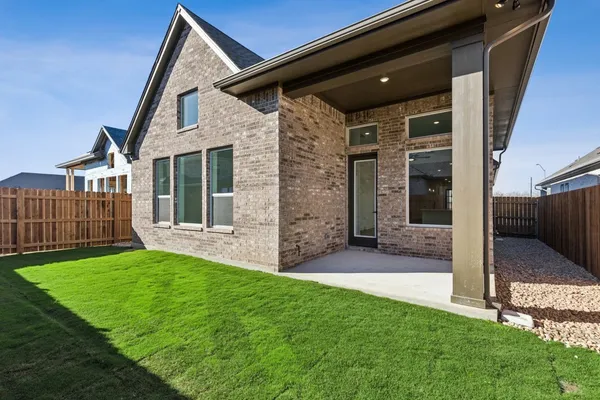 a view of a house with a yard and wooden fence