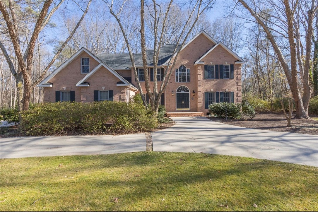 1104 Thornehill Drive Anderson, SC 29621 - Photo 1 of 35 A classic brick residence nestled among mature trees, featuring an expansive driveway and lush landscaping.
