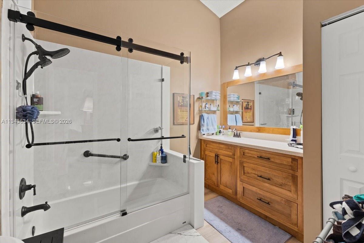 7120 Southwest 112th Avenue Miami, FL 33173 - Photo 12 of 27 a bathroom with a granite countertop sink mirror and a bathtub