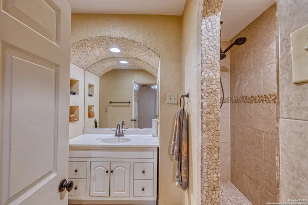 a bathroom with a sink a toilet and shower