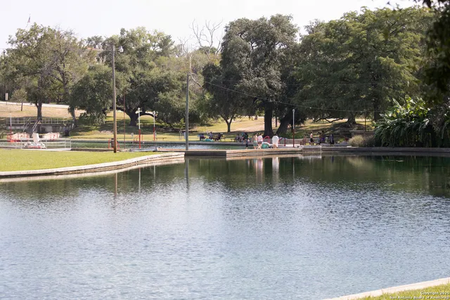 a view of a lake with a big yard and large trees