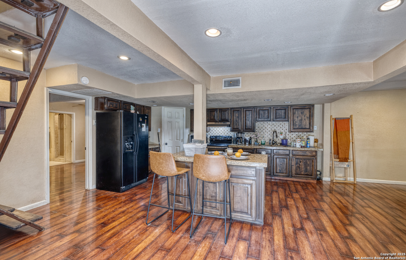 155 Avenida Juarez Road Brackettville, TX 78832 - Photo 7 of 37 a kitchen with stainless steel appliances kitchen island granite countertop wooden floors and wooden cabinets