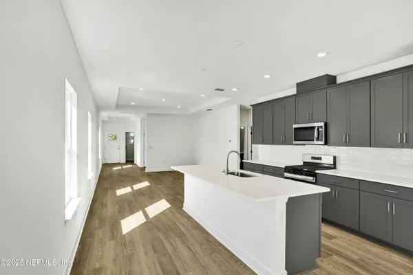 a kitchen with kitchen island sink stove and refrigerator