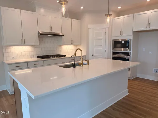 a kitchen with kitchen island a sink a stove and a refrigerator