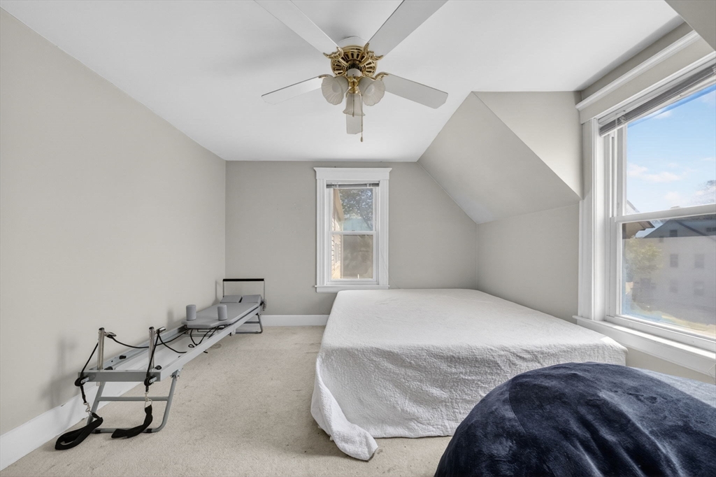 114 Lovell Street Worcester, MA 01603 - Photo 11 of 32 a bedroom with a bed and a chandelier