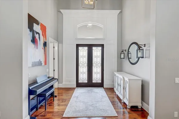 a open kitchen with stainless steel appliances granite countertop a dining table chairs and wooden floor