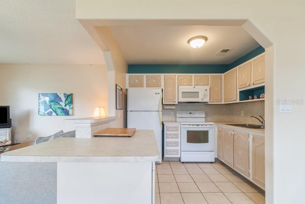 11723 Boynton Lane, Unit 1 New Port Richey, FL 34654 - Photo 13 of 31 a kitchen with stainless steel appliances a stove a sink and a refrigerator