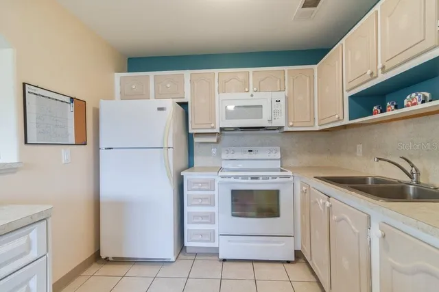 a kitchen with a refrigerator sink and cabinets