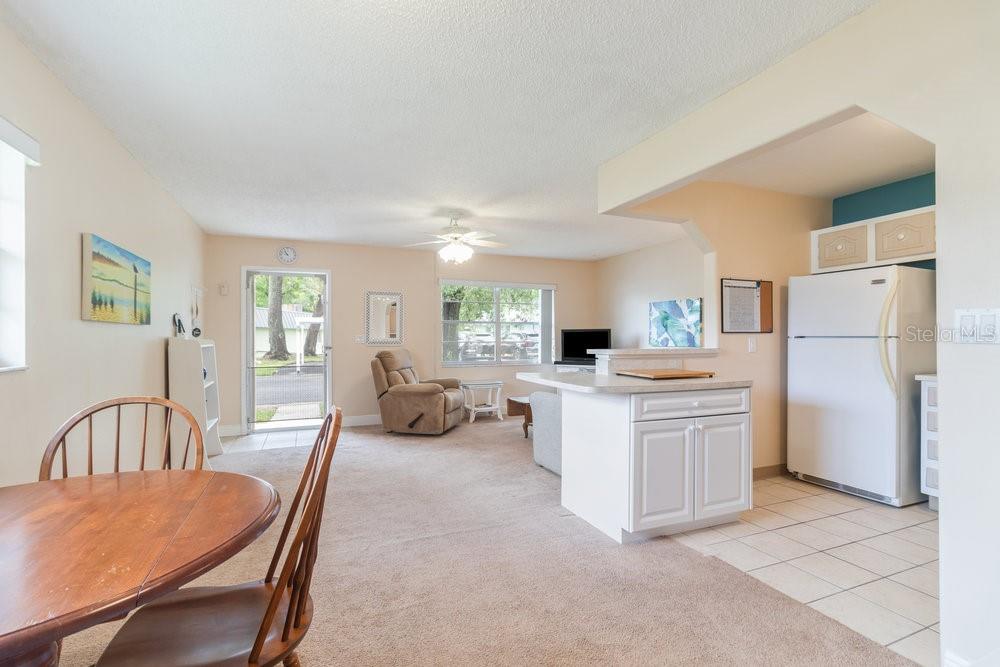 11723 Boynton Lane, Unit 1 New Port Richey, FL 34654 - Photo 19 of 31 a large white kitchen with a refrigerator a stove a dining table and chairs