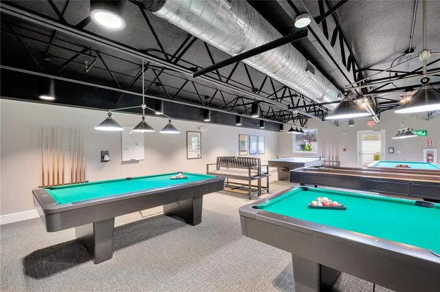 a room with pool table wooden floor and windows