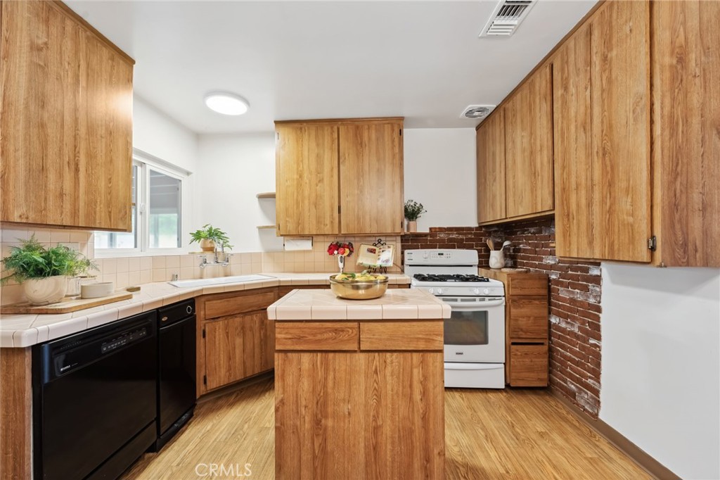 3035 Priscilla Street Riverside, CA 92506 - Photo 14 of 45 a kitchen with a sink stove and cabinets