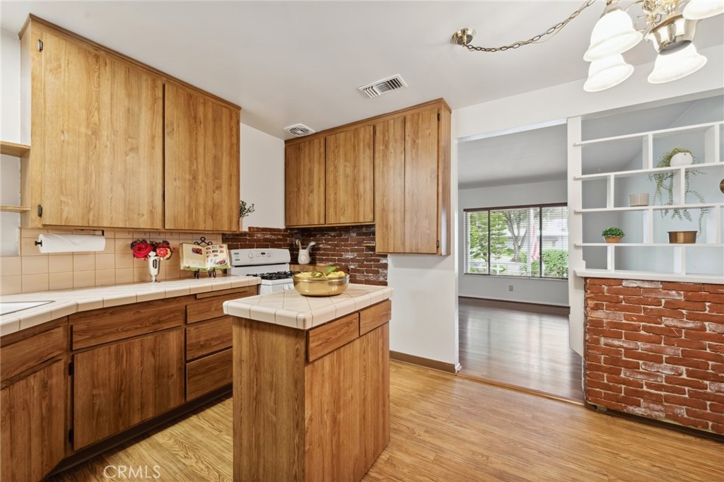 3035 Priscilla Street Riverside, CA 92506 - Photo 9 of 45 a kitchen with stainless steel appliances a sink cabinets and wooden floor