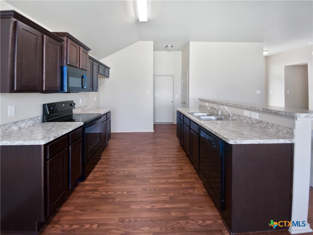 2501 Stoneham Temple, TX 76504 - Photo 12 of 19 a kitchen with stainless steel appliances granite countertop a stove top oven a sink dishwasher and a refrigerator with wooden cabinets