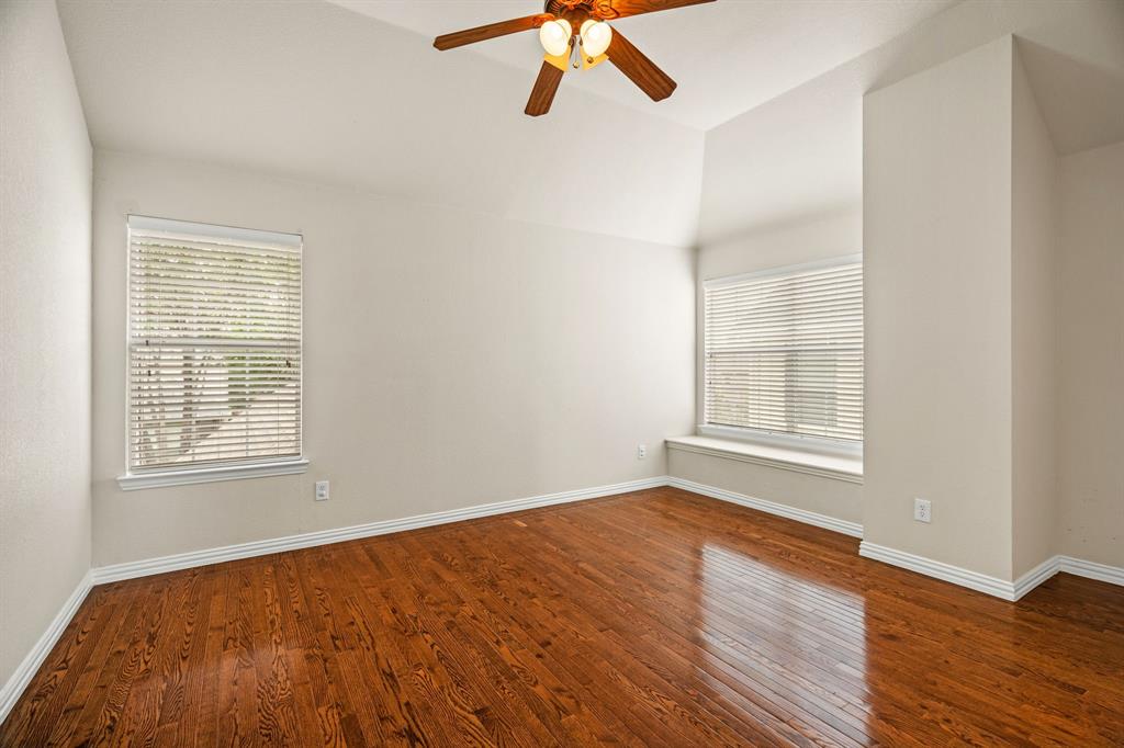 2012 Burnside Drive Allen, TX 75013 - Photo 35 of 40 an empty room with wooden floor chandelier fan and windows