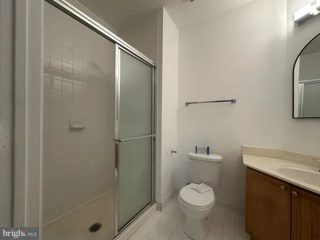 a bathroom with a granite countertop toilet a sink and a shower