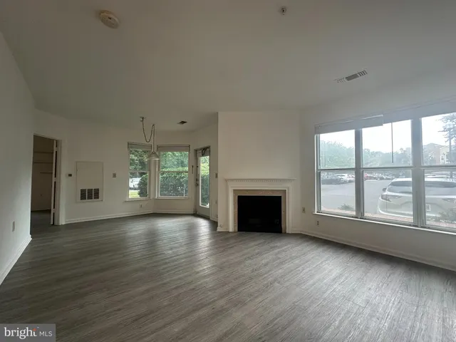 a view of empty room with wooden floor and fireplace