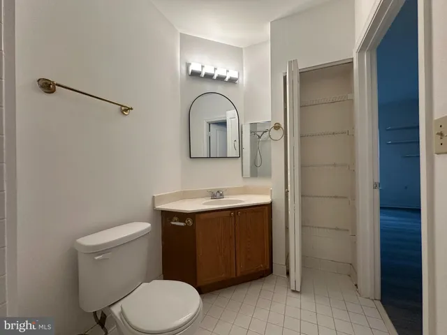 a bathroom with a toilet sink vanity and mirror