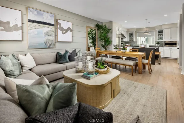 a living room with furniture kitchen view and a large window