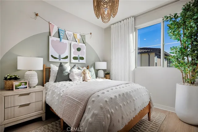 a bedroom with a bed and a potted plant on the dresser