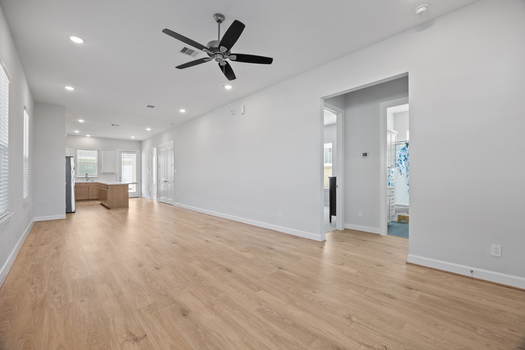 2505 South Houston Avenue Pearland, TX 77581 - Photo 12 of 24 a view of a livingroom with a ceiling fan & wooden floor