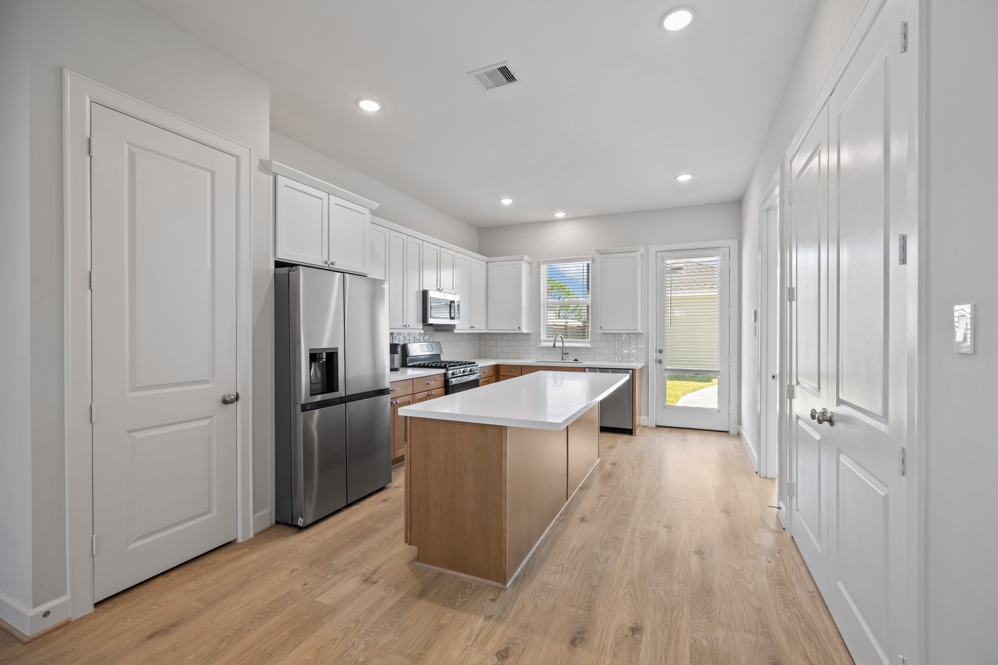 2505 South Houston Avenue Pearland, TX 77581 - Photo 5 of 24 a large kitchen with stainless steel appliances granite countertop a large counter top a sink and a refrigerator
